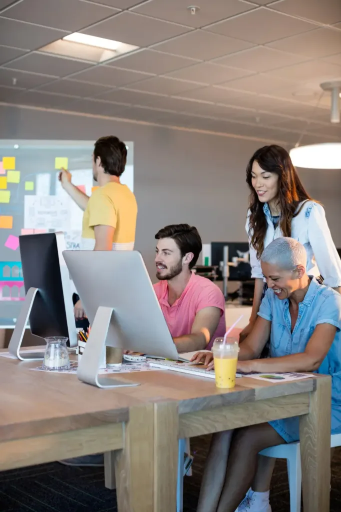 Creative business team working together on desktop pc in office